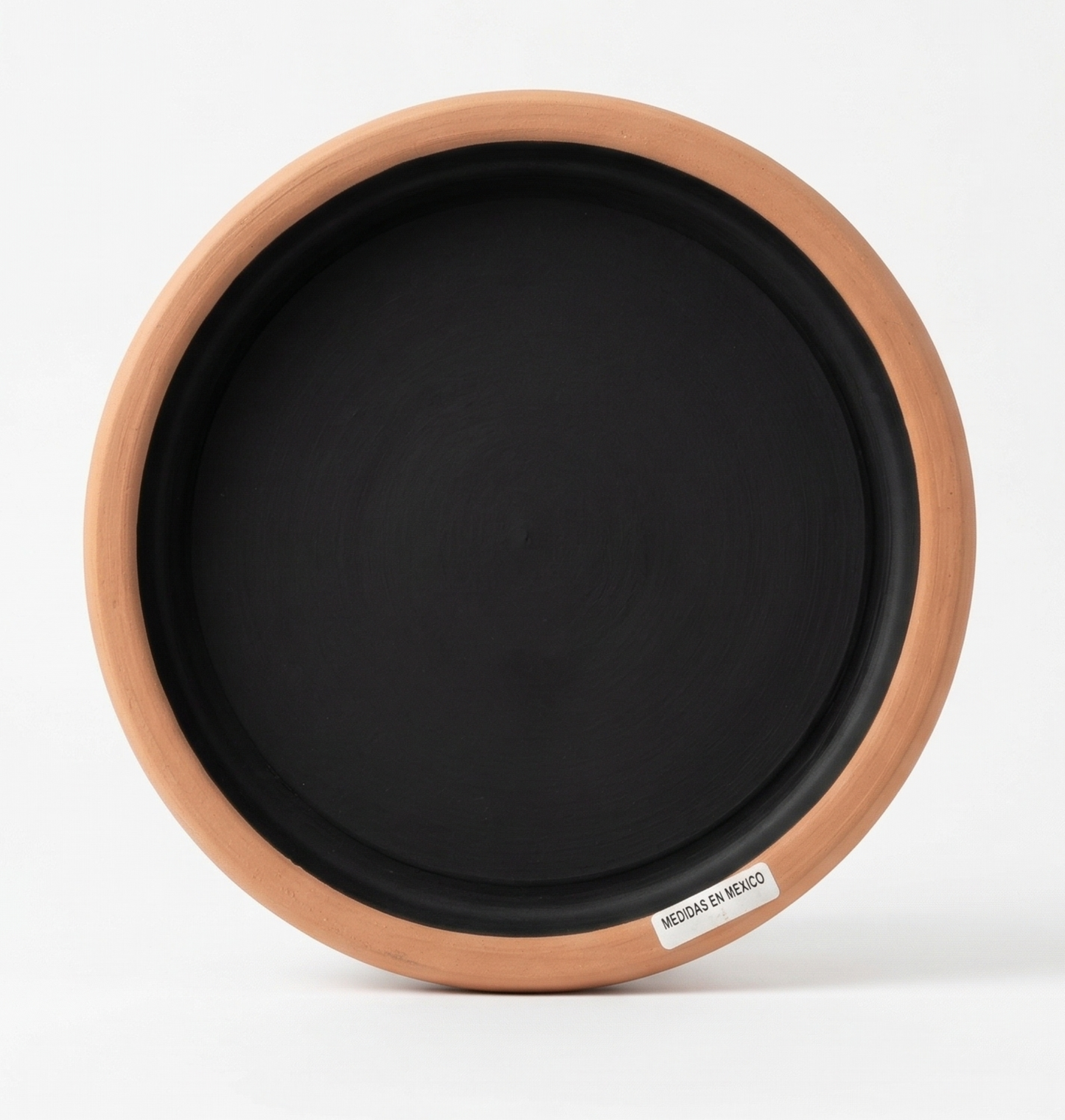 Round terracotta planter saucer with black interior by Clay Imports, featuring a "MEDIDAS EN MEXICO" label.
