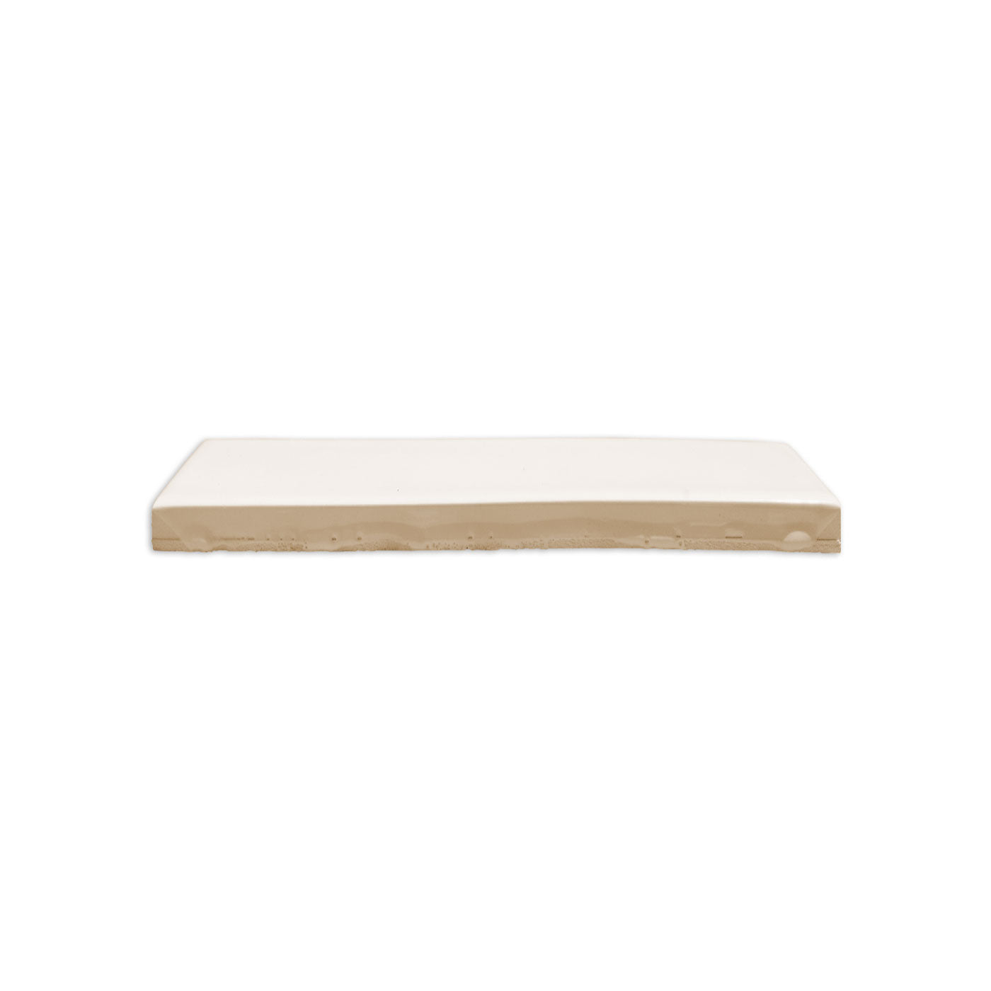 Fossil Gloss solid tile by Clay Imports, a glossy off-white rectangular tile with a raw beige base from a side view.