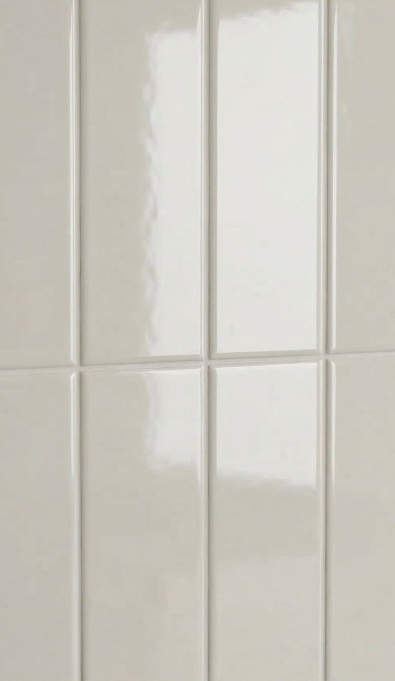 Light beige glossy rectangular clay tiles by Clay Imports, arranged vertically with subtle grout lines.