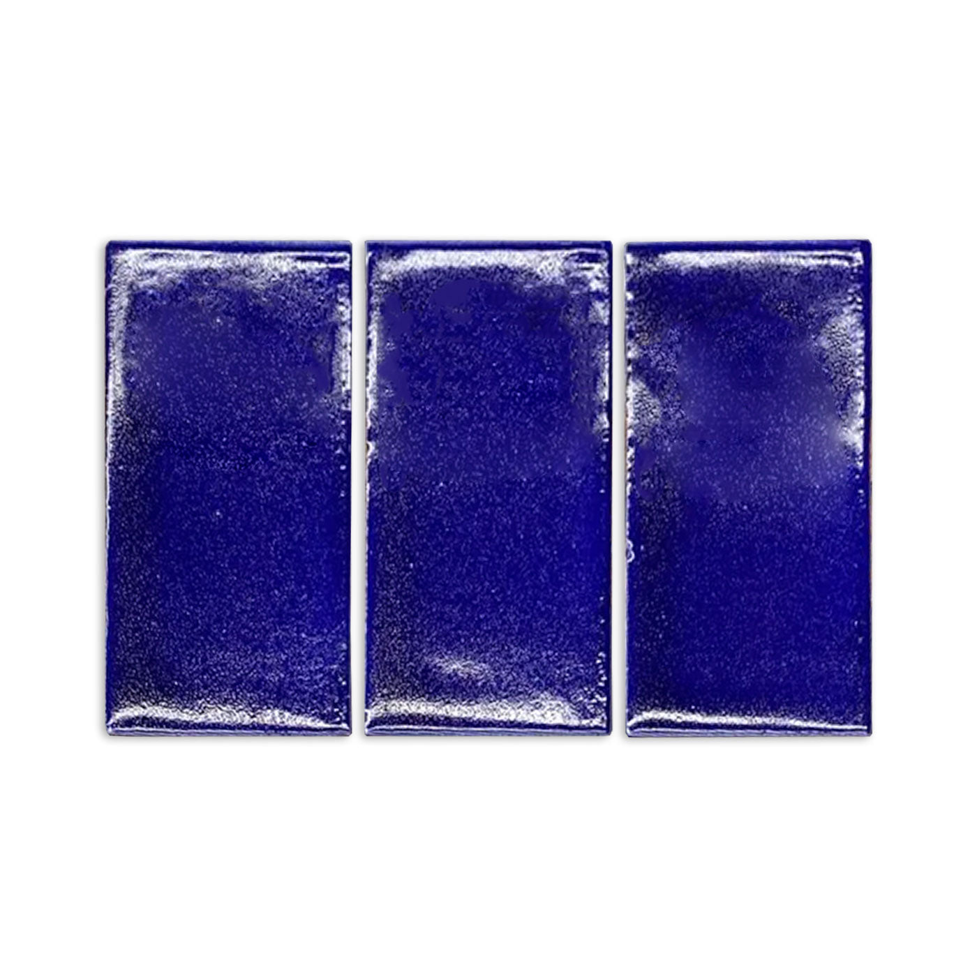 Three rectangular cobalt blue gloss tile samples by Clay Imports with a handmade, slightly textured finish.