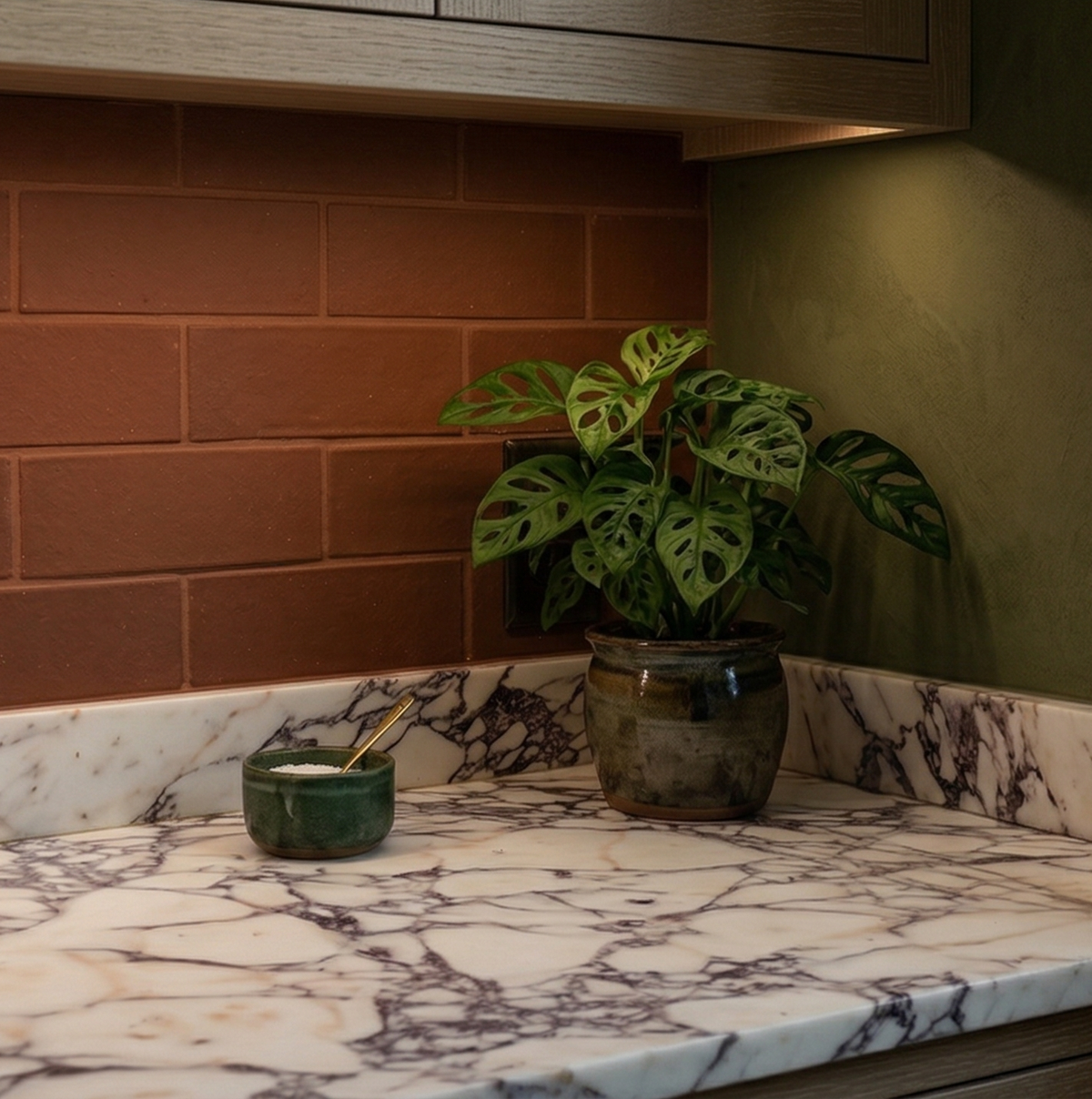 Textured reddish-brown Cotto Tierra 2x6 tiles by Clay Imports as a kitchen backsplash above marble countertops.