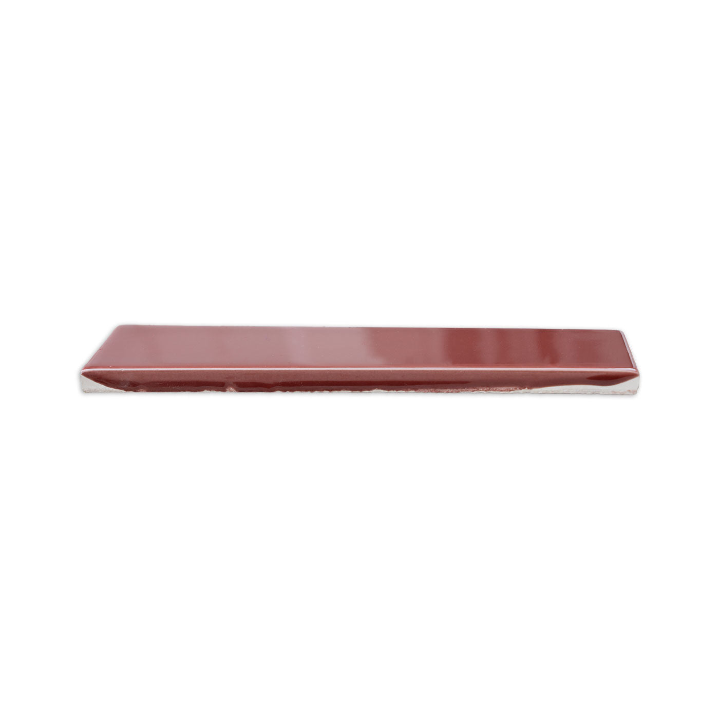 Burgundy gloss rectangular sample tile by Clay Imports, showing its unglazed edge from a side view.