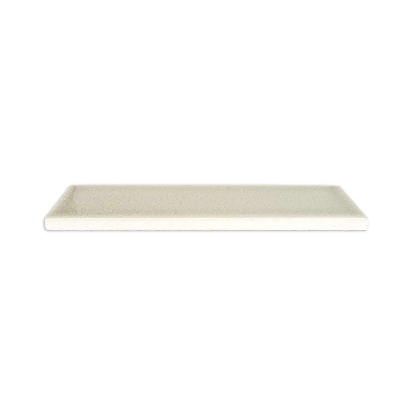 Light beige rectangular solid tile by Clay Imports with a glossy crackle finish, side view.