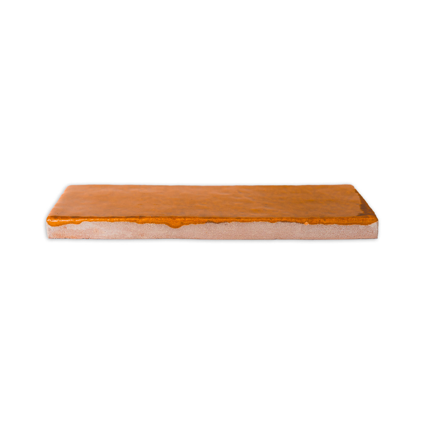 Terra Crackle glazed thin brick by Clay Imports, featuring a glossy orange-brown surface and rough light gray edge.