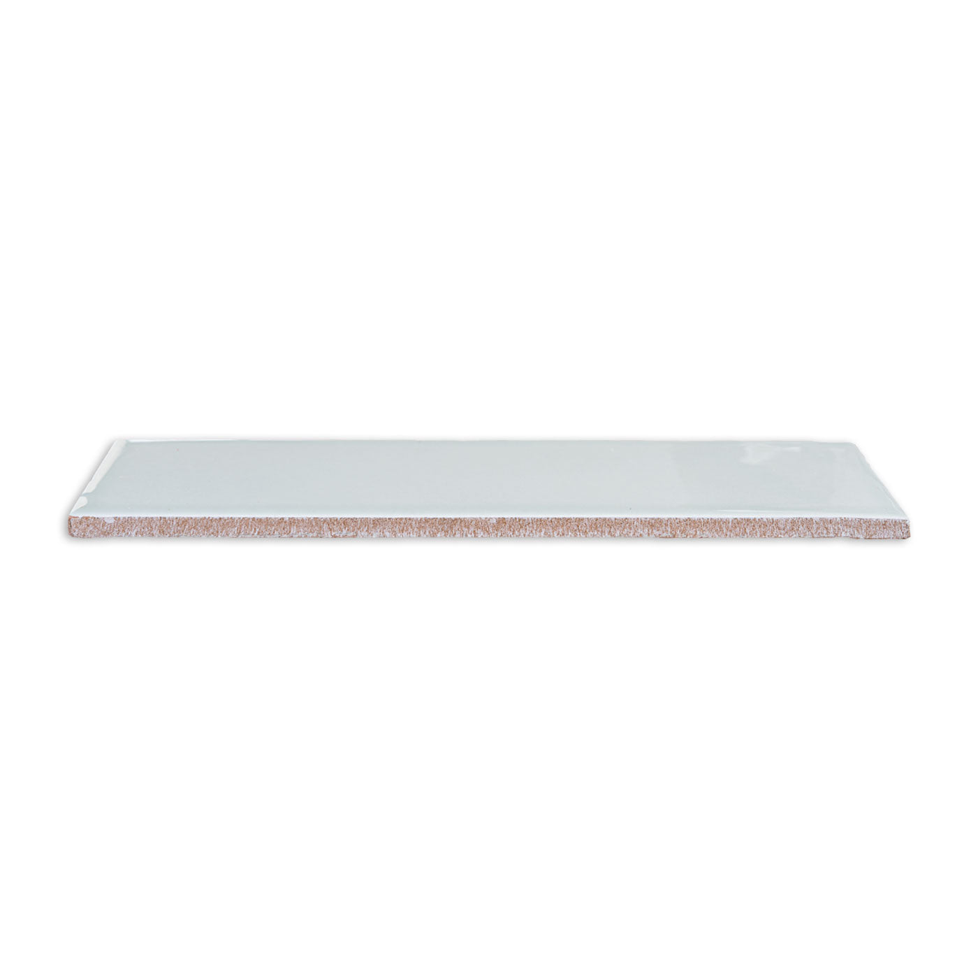 Spearmint green 3x12 solid tile by Clay Imports with a glossy finish and visible reddish-brown unglazed edge, viewed at an angle.