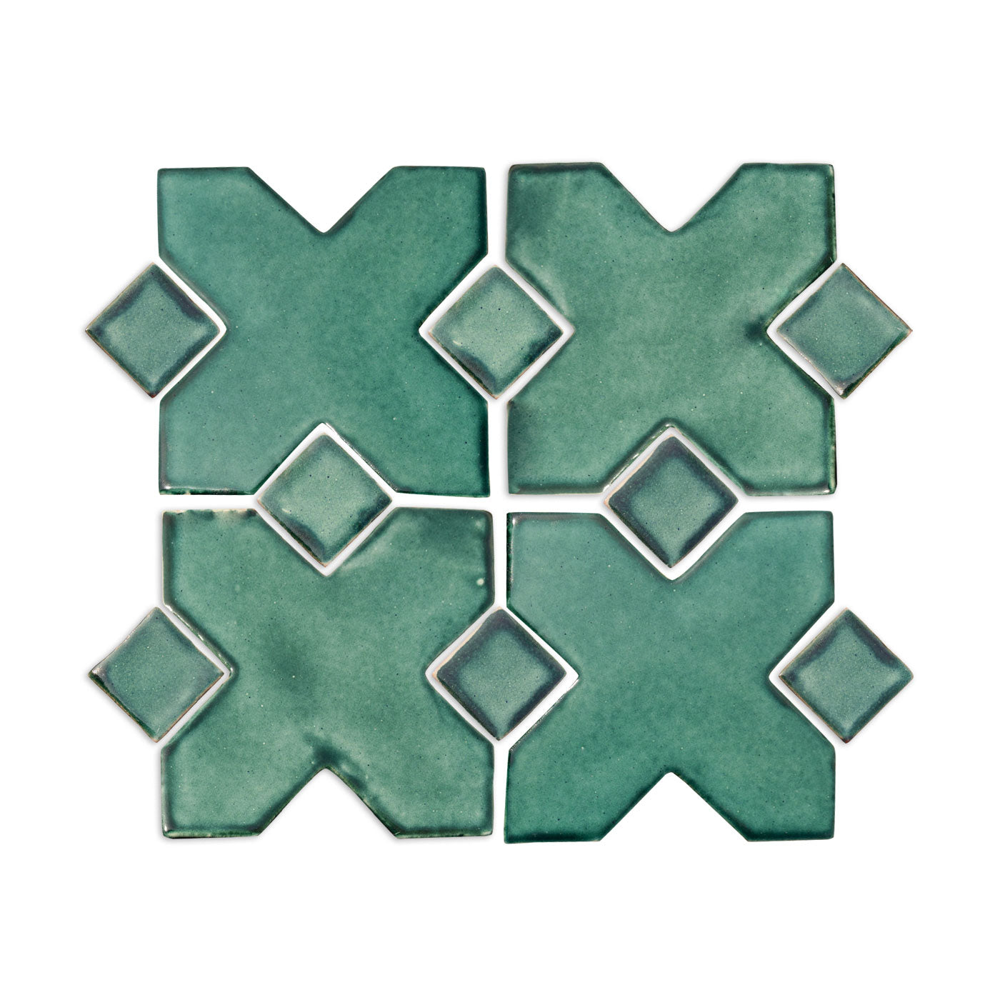 A Grotto Green tile sample by Clay Imports displaying four interlocking X-shaped tiles and diamond-shaped inserts.