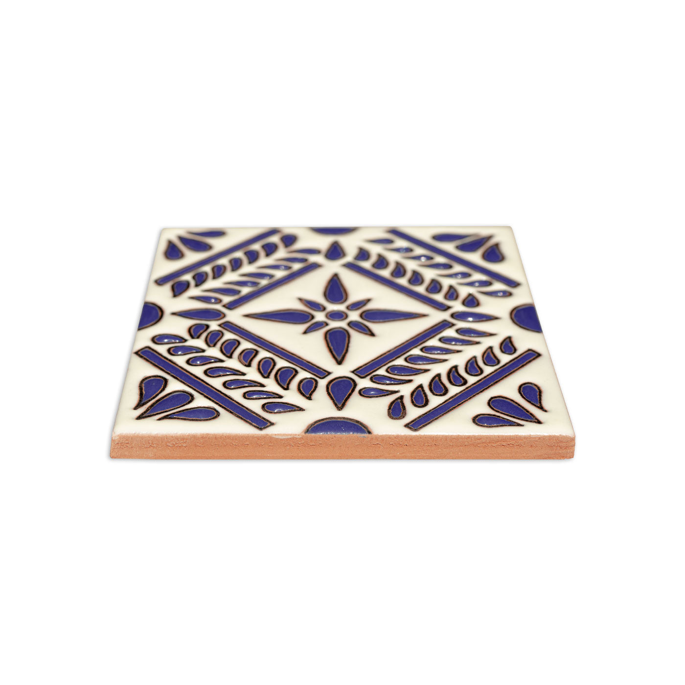 Blue and white Relief Talavera tile by Clay Imports with an intricate floral design and unglazed reddish-brown side.