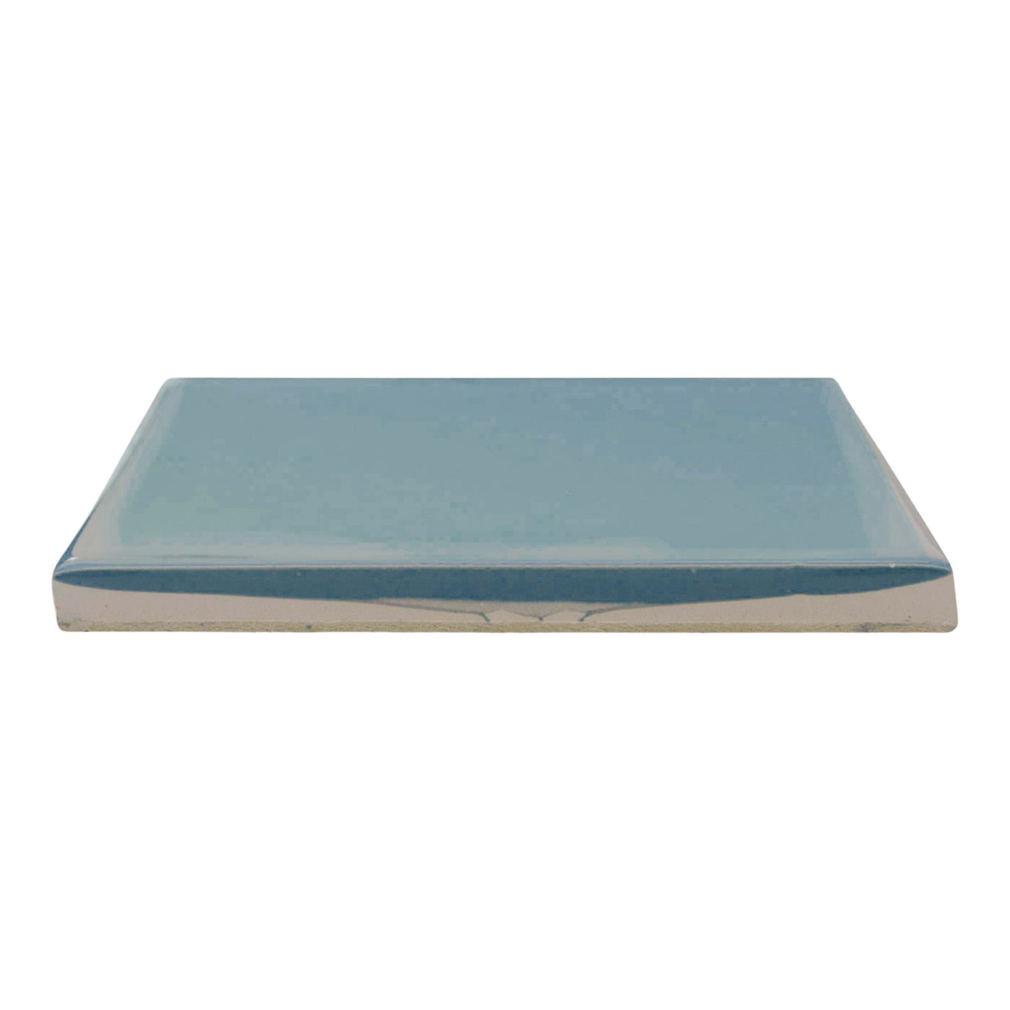 Glossy light blue-green solid tile by Clay Imports, shown in side profile with a darker blue glazed edge and an unglazed ceramic base.