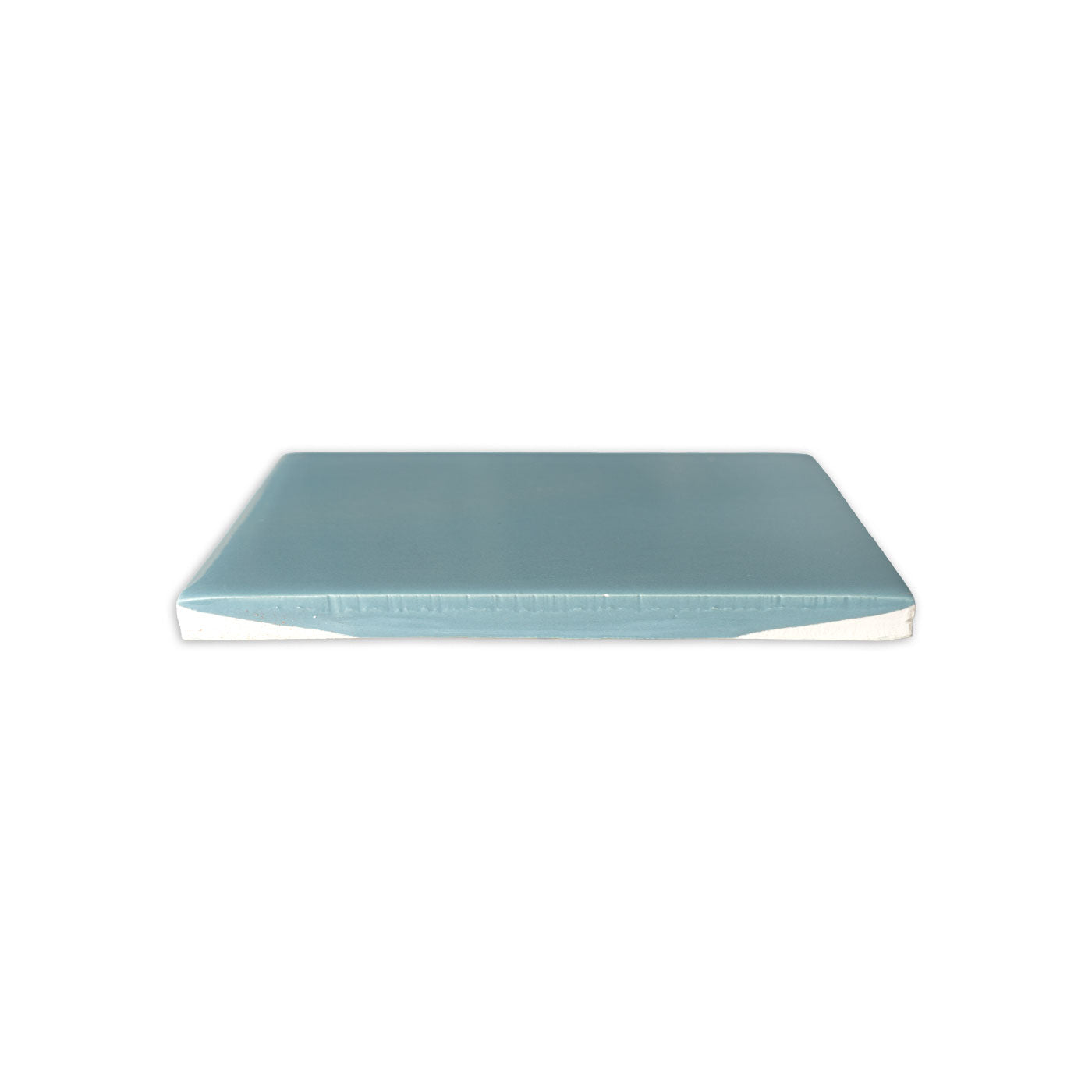 Dragonfly Gloss 4x4 solid tile by Clay Imports, in muted blue-green with a glossy finish, showing its white raw edge.