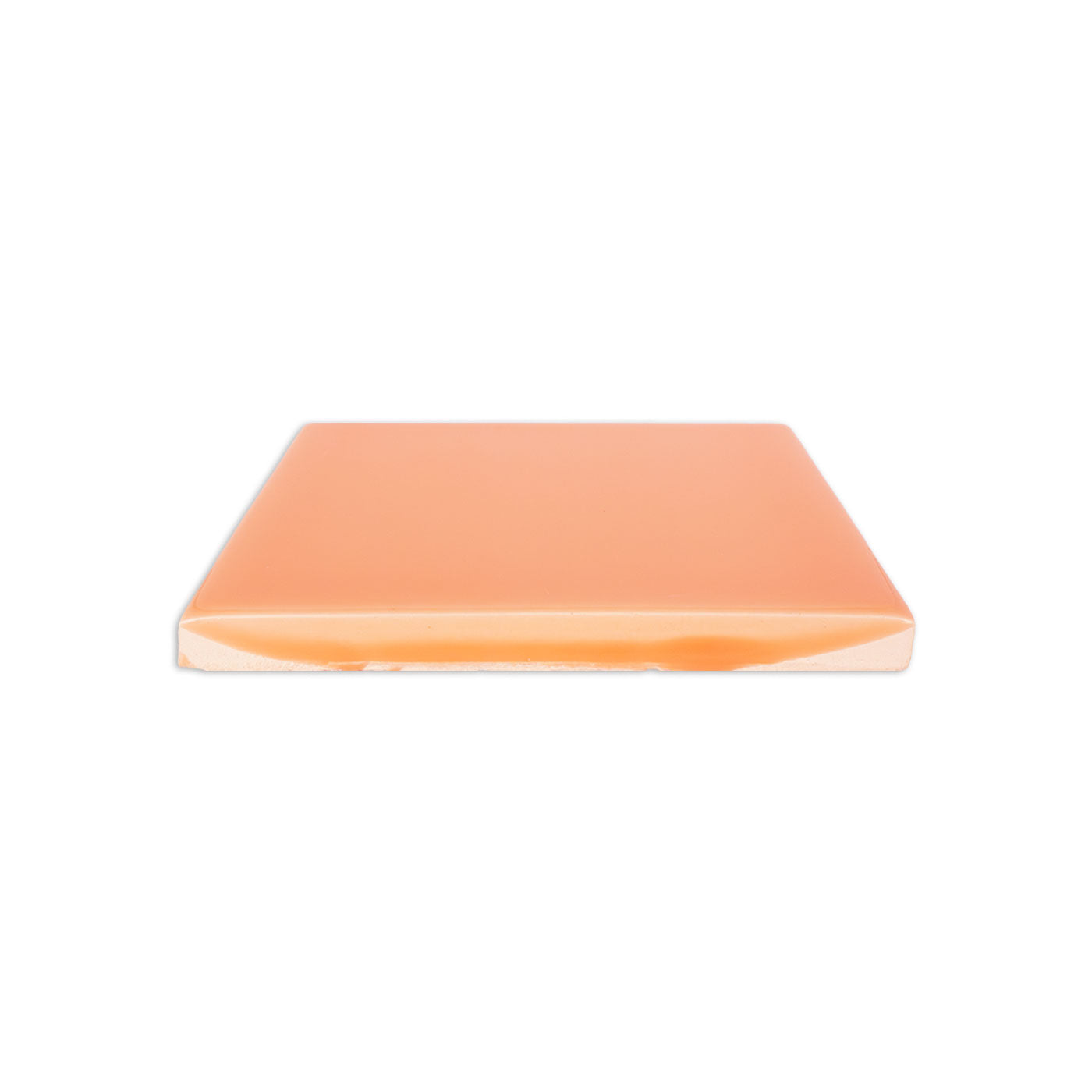 Glossy peach solid tile by Clay Imports, shown from a side view revealing its unglazed edge.