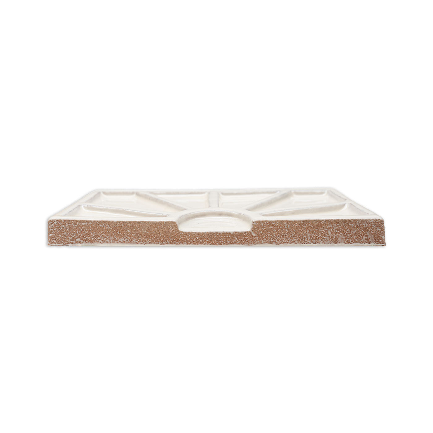 White and terracotta clay tile by Clay Imports, showing a geometric relief pattern on its glazed back from the side.