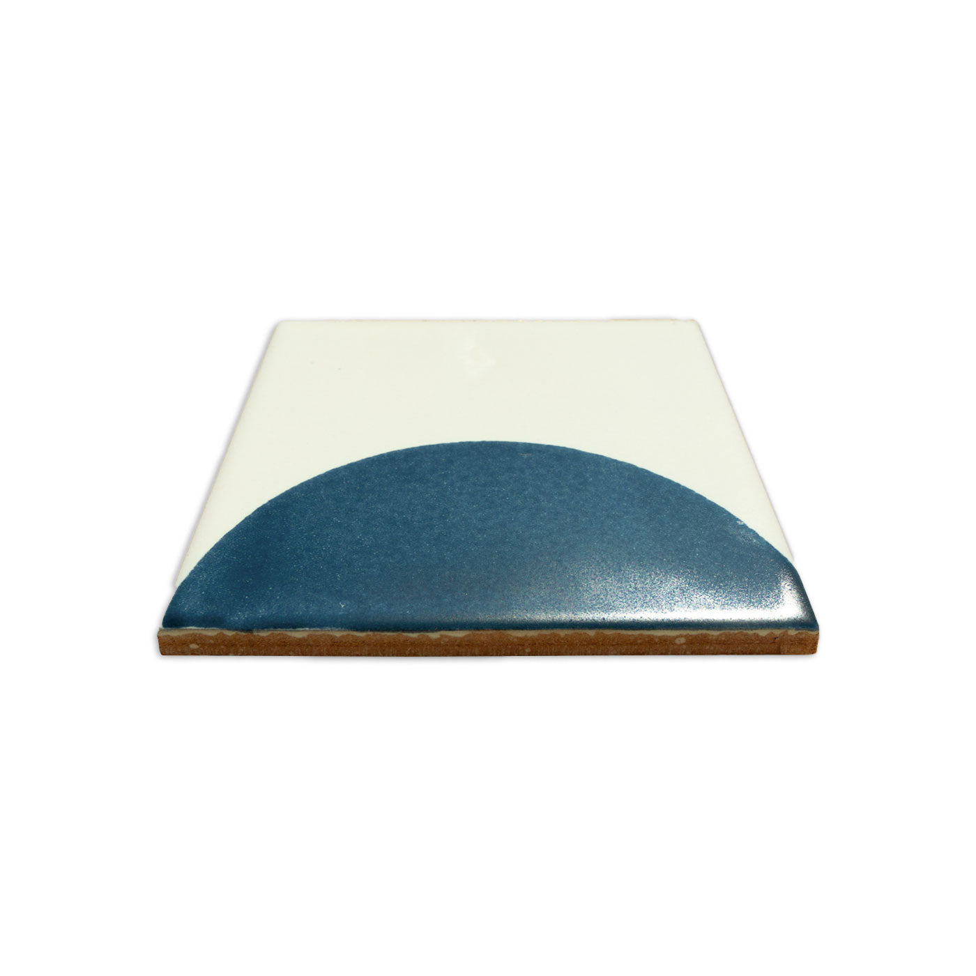 White ceramic tile by Clay Imports, featuring a glossy blue semi-circle design and unglazed brown sides.