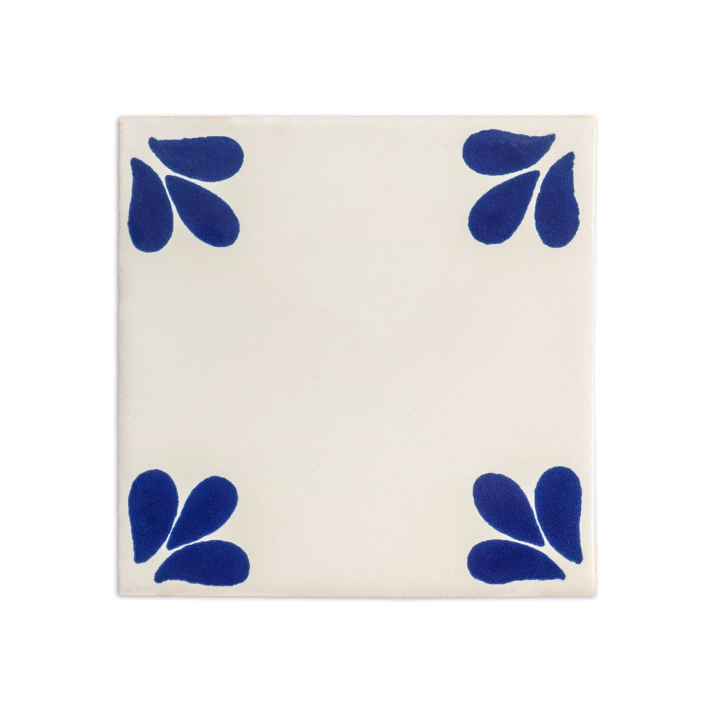 Square cream Talavera tile sample from Clay Imports Handmade Tile with four blue petal designs in the corners.