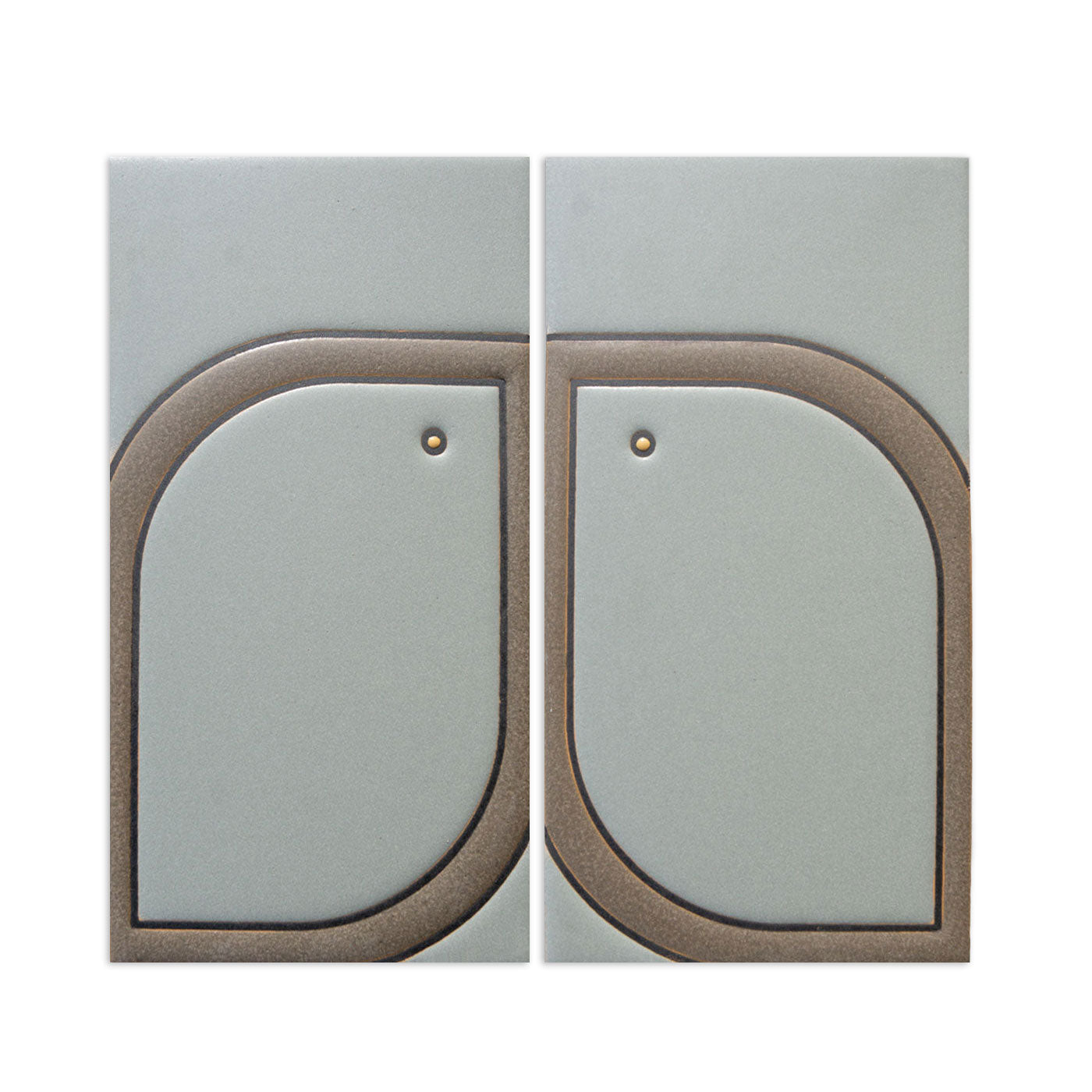 Two light gray-green Pio Pio Petit Agave tiles by Clay Imports, featuring a bronze raised, mirrored leaf design with central dots.