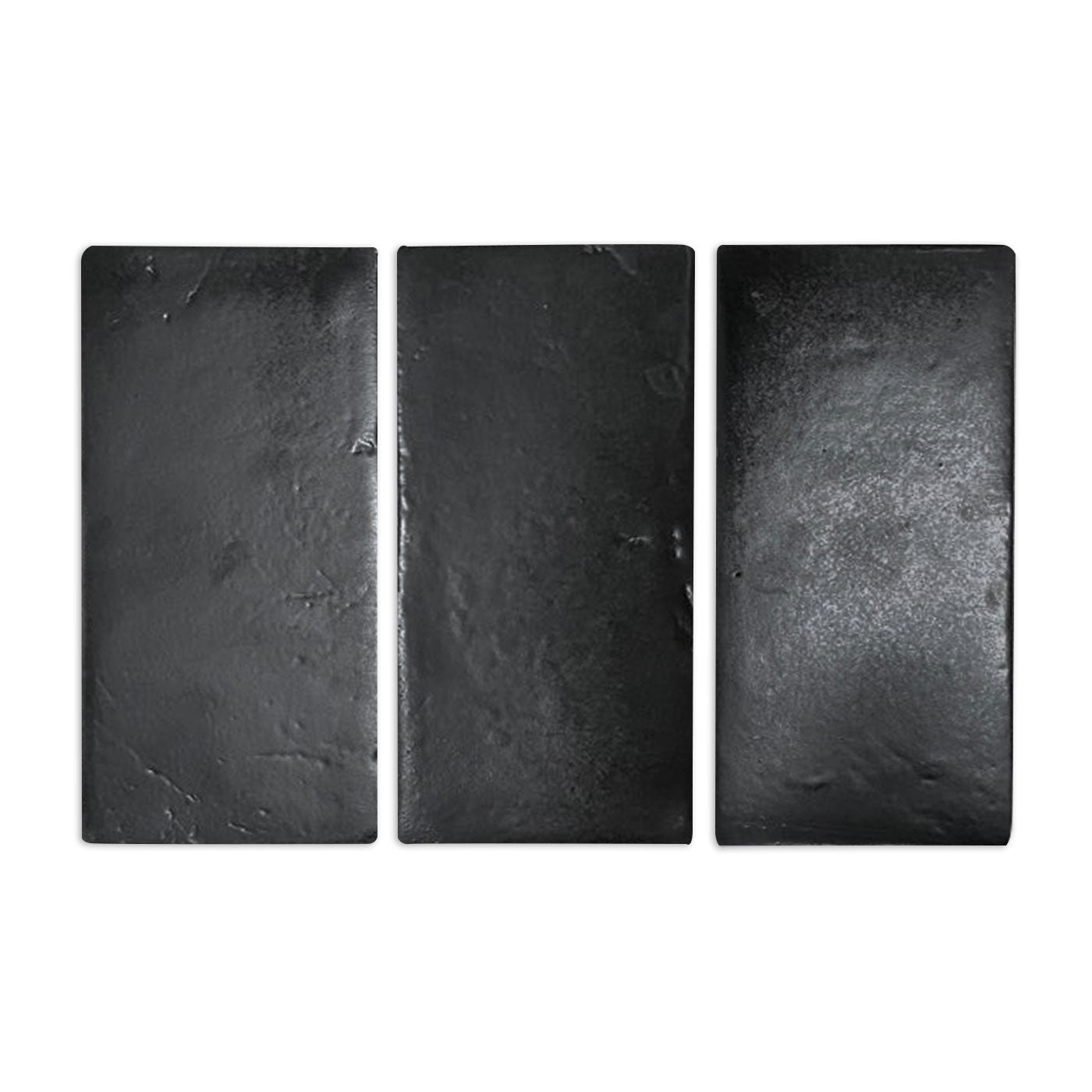 Three black rectangular sample tiles by Clay Imports with glazed, textured finishes.