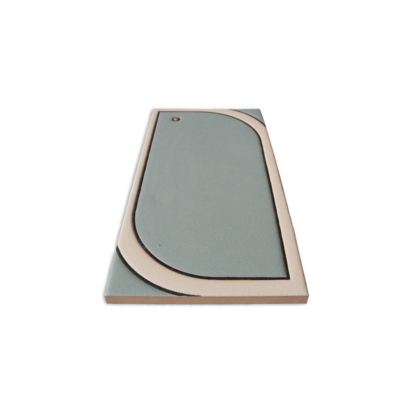 Sage green and beige rectangular ceramic tile by Clay Imports, with a rounded geometric design and small dark dot, angled.
