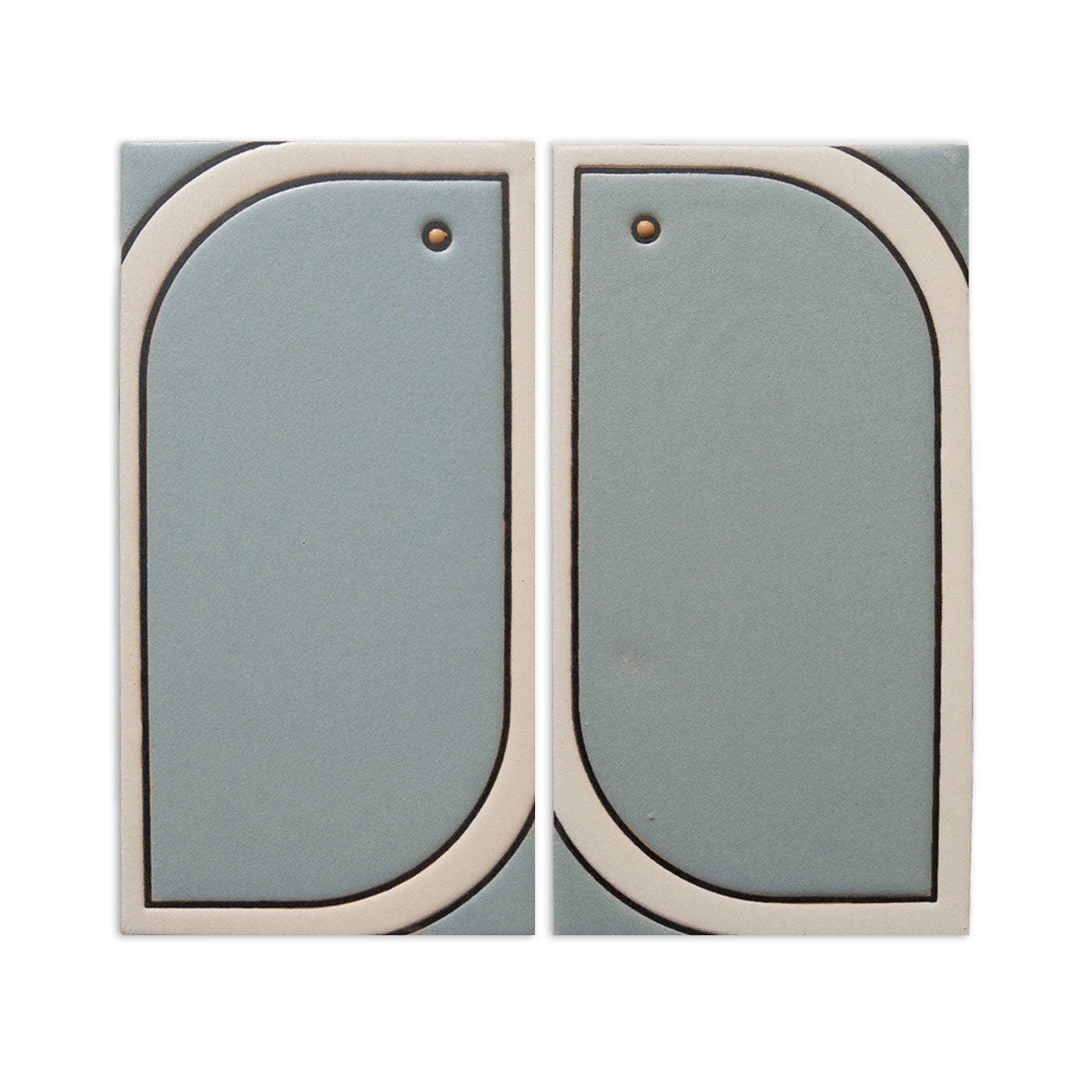 Two rectangular agave-colored tile samples by Clay Imports, with rounded cream borders and small top holes.