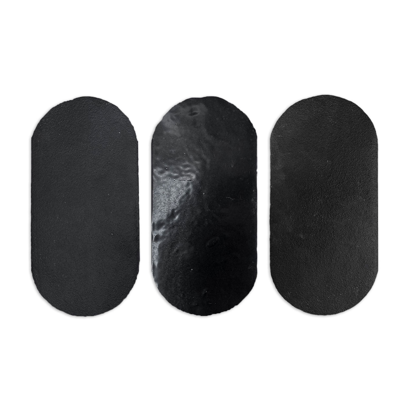 Black glazed Uvas Noir sample by Clay Imports, featuring three oblong pieces with varied textures including glossy and matte.
