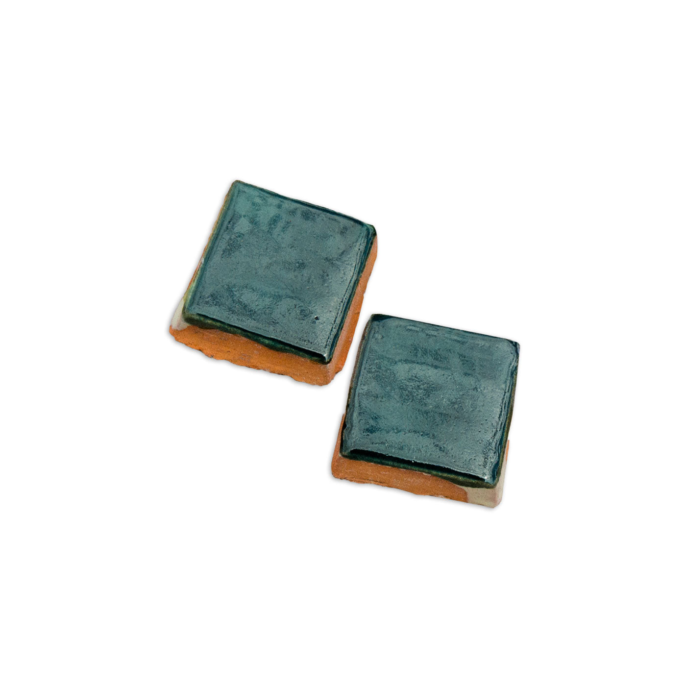 Two square ceramic tiles with dark teal green glossy glaze by Clay Imports, featuring rustic terracotta bases.