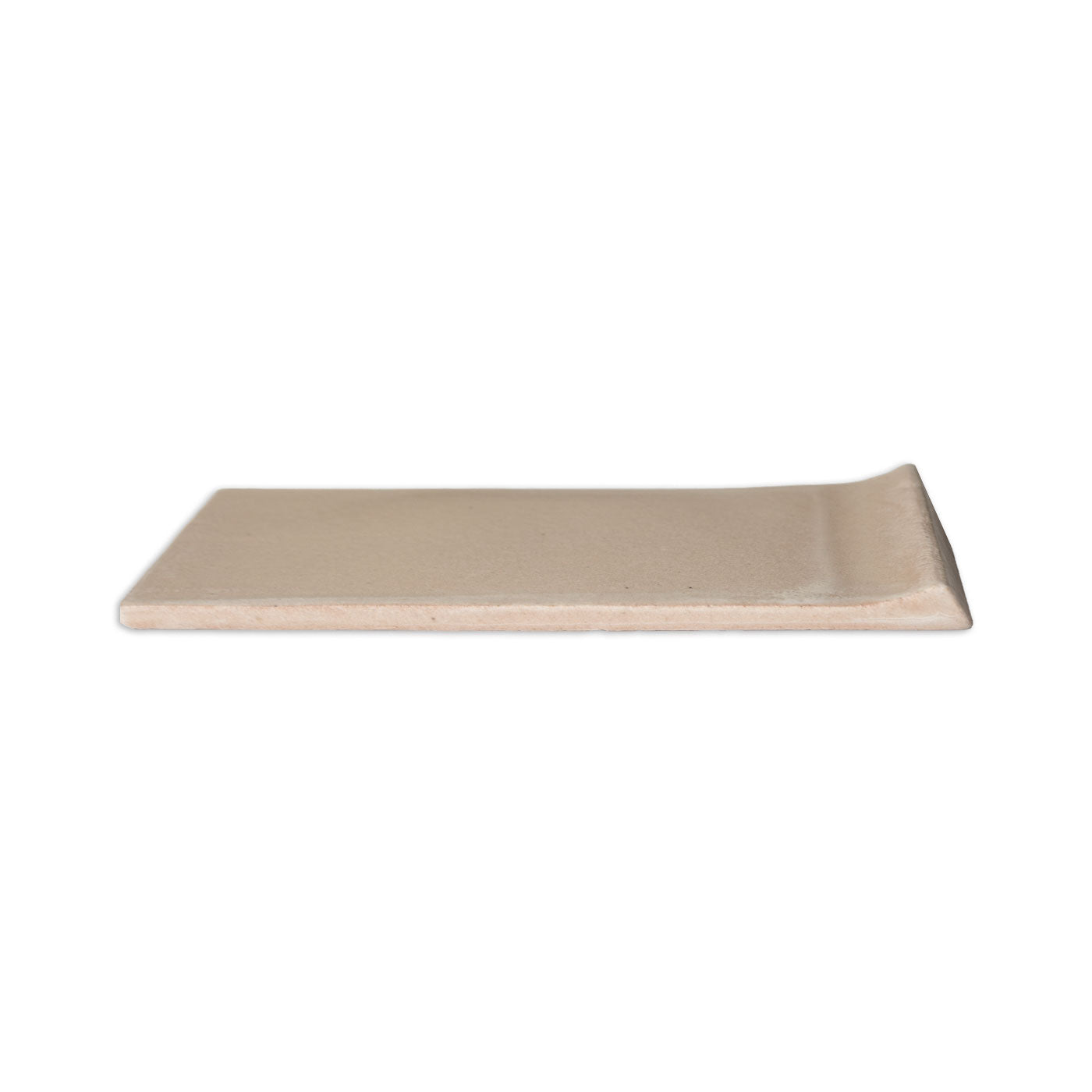 A rectangular beige matte tile by Clay Imports, with a subtly raised edge, viewed from a side angle.