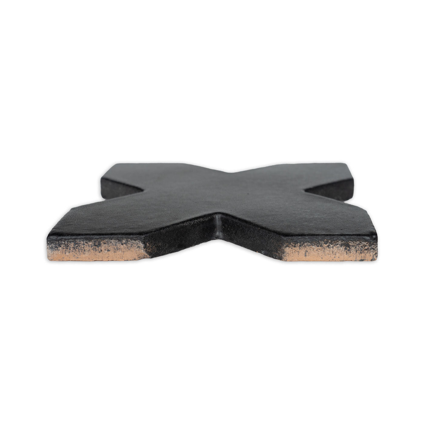 Black suede Star & Cross tile by Clay Imports, seen from a side angle showing its raw clay edge.