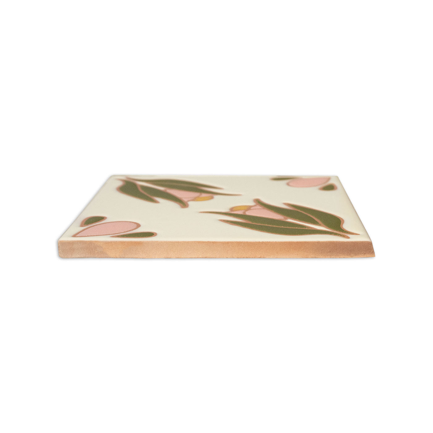 Relief Talavera tile by Clay Imports, featuring a creamy floral pattern with pink and green leaves, seen from the side with a natural edge.