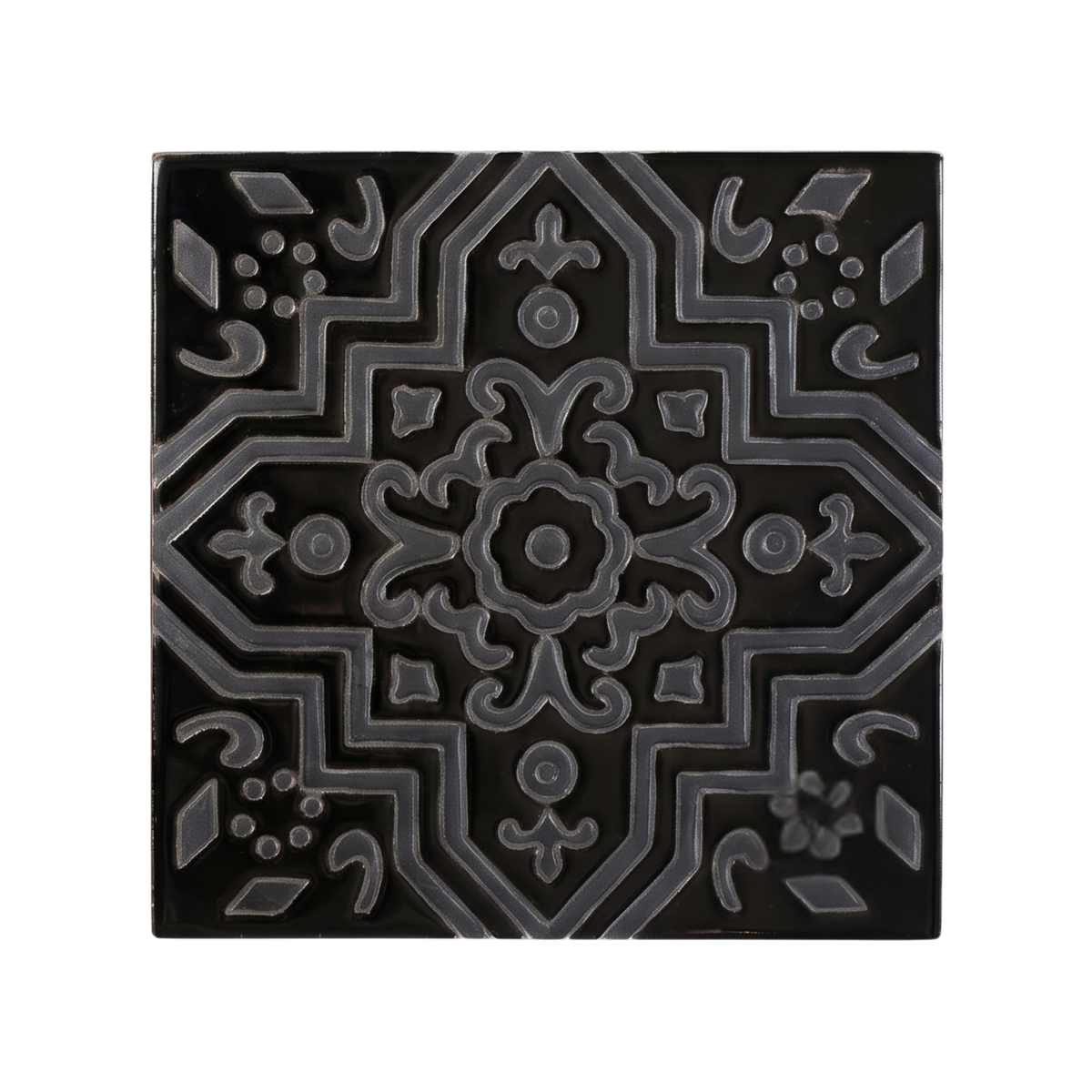 A square, black ceramic tile displays an embossed geometric and floral pattern in a contrasting dark gray outline.