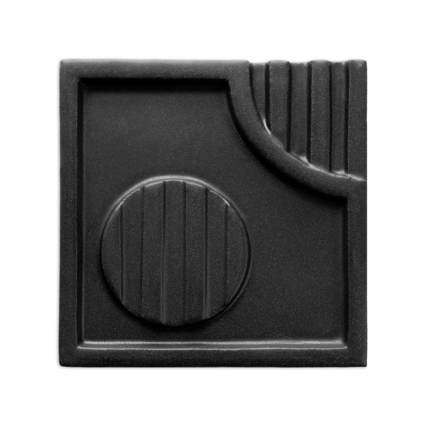 Black geometric tile by Clay Imports with a suede finish, featuring raised square, circular, and vertical ridged patterns.