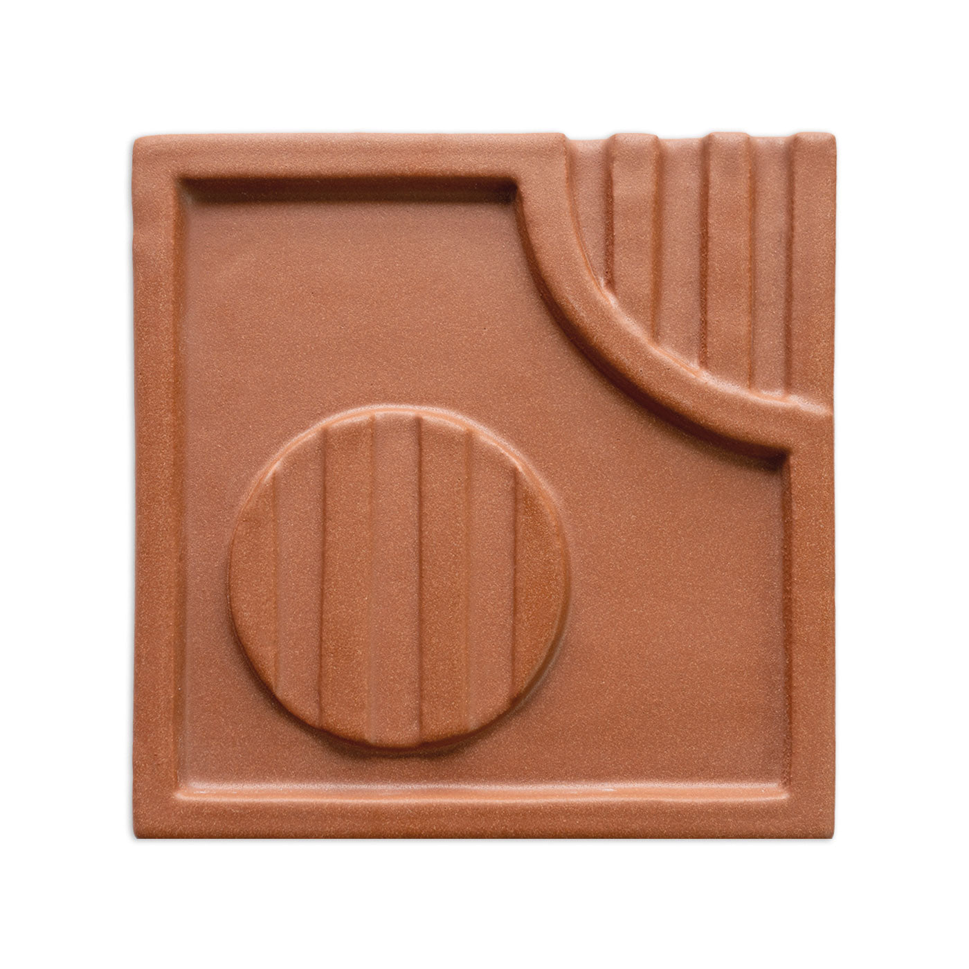 Terracotta-colored decorative tile by Clay Imports, featuring raised geometric patterns with a central circle and curved elements.