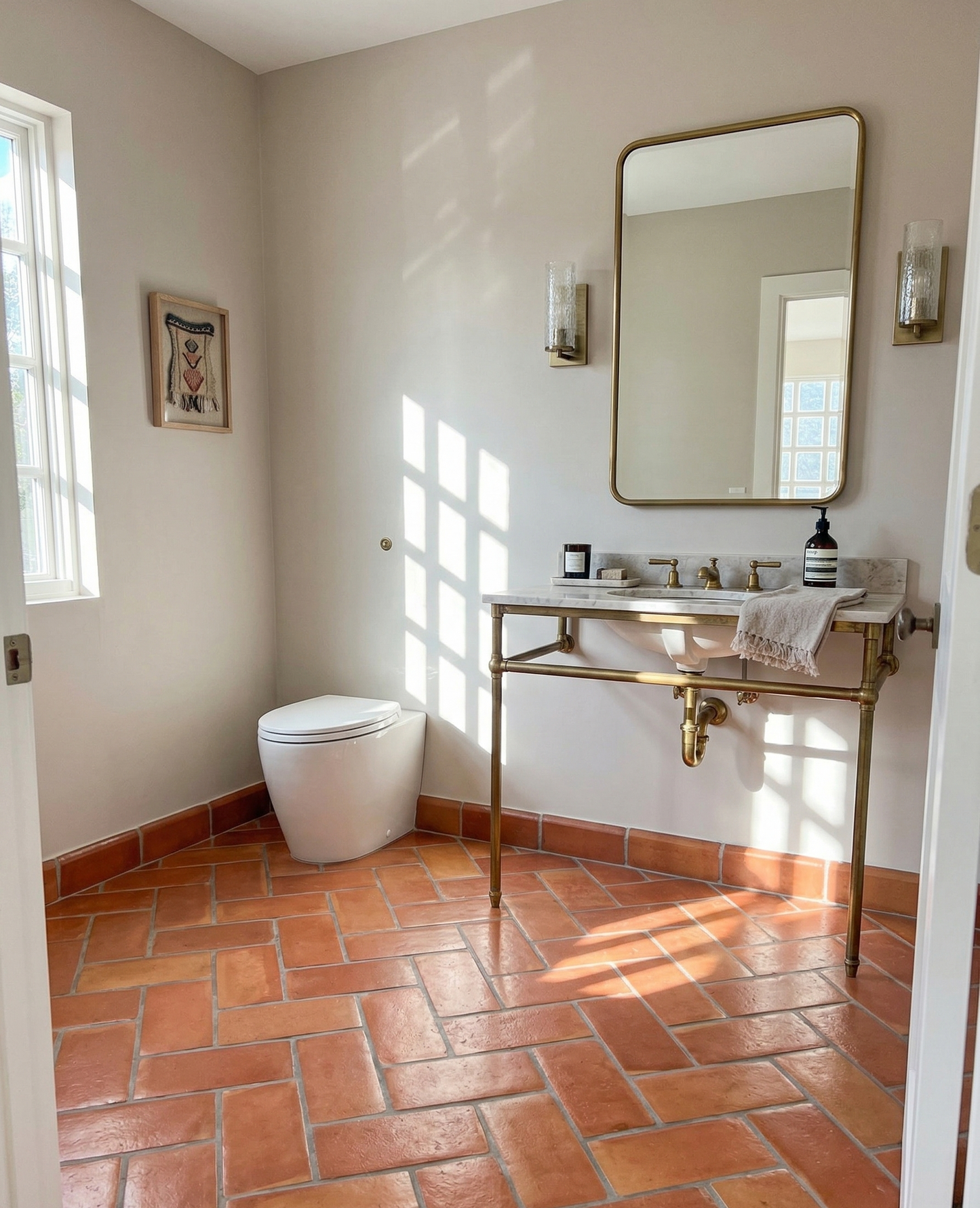 Smooth Gloss 6x12 terracotta floor tiles by Clay Imports, laid in a warm, patterned layout with light gray grout, on a sunlit bathroom floor.