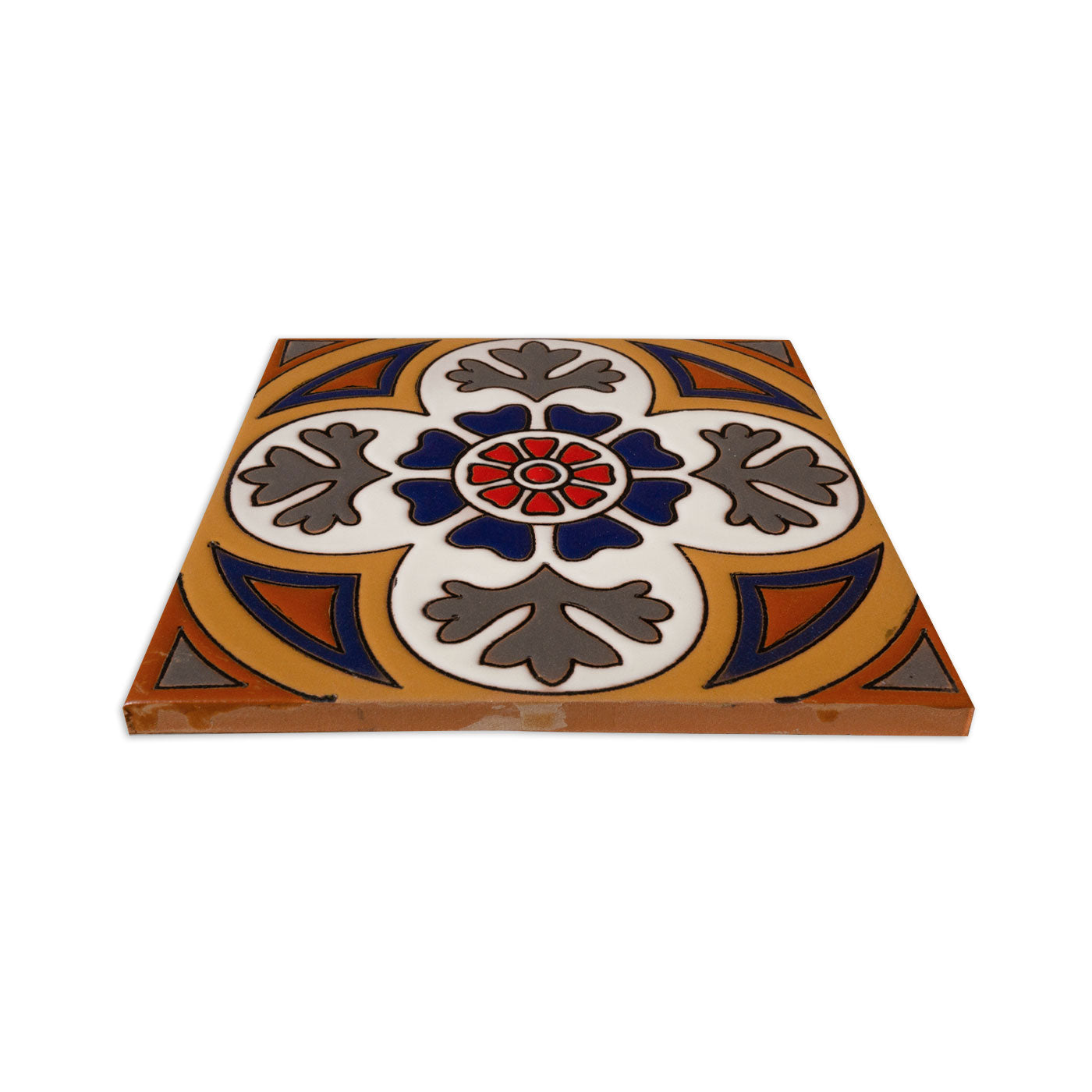 Relief Talavera tile by Clay Imports, with a central red and blue floral design surrounded by white and gray motifs on a golden-brown background, angled view.