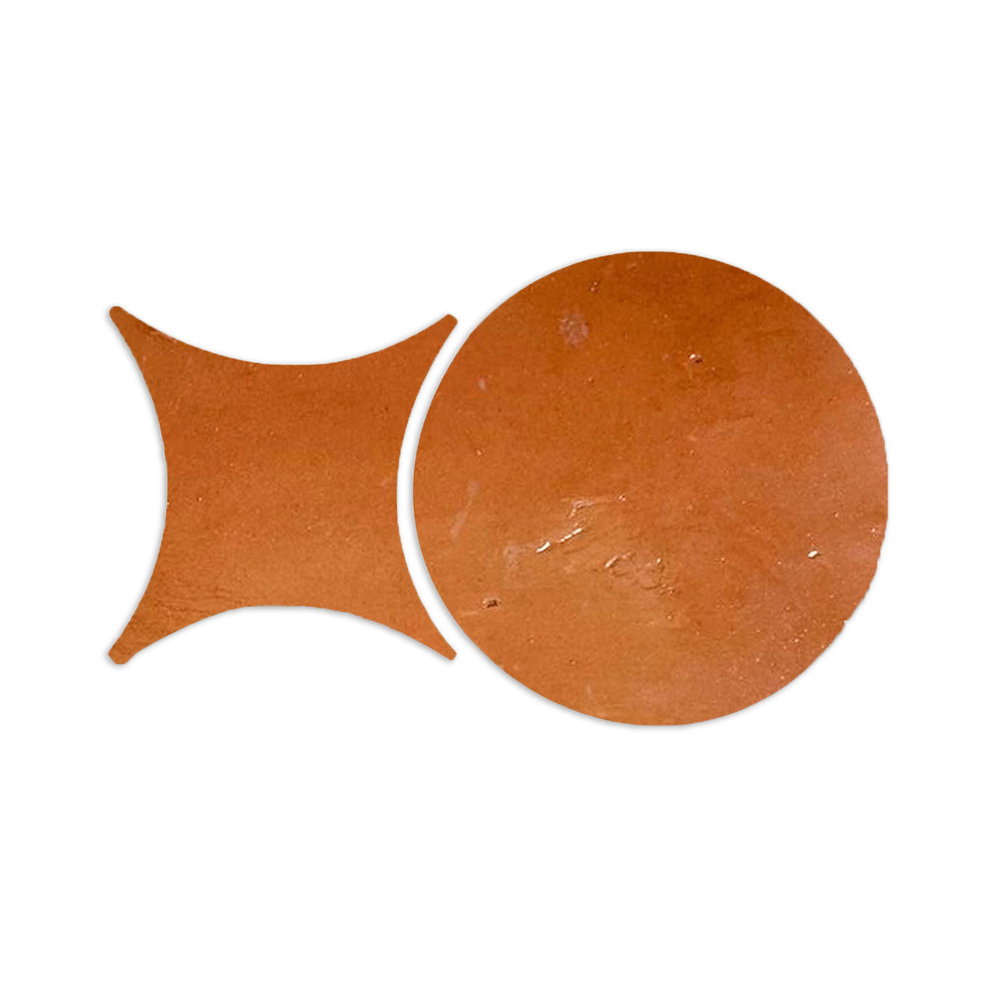 Two terracotta-colored, smooth gloss tile samples by Clay Imports, one round and one rombo-shaped.