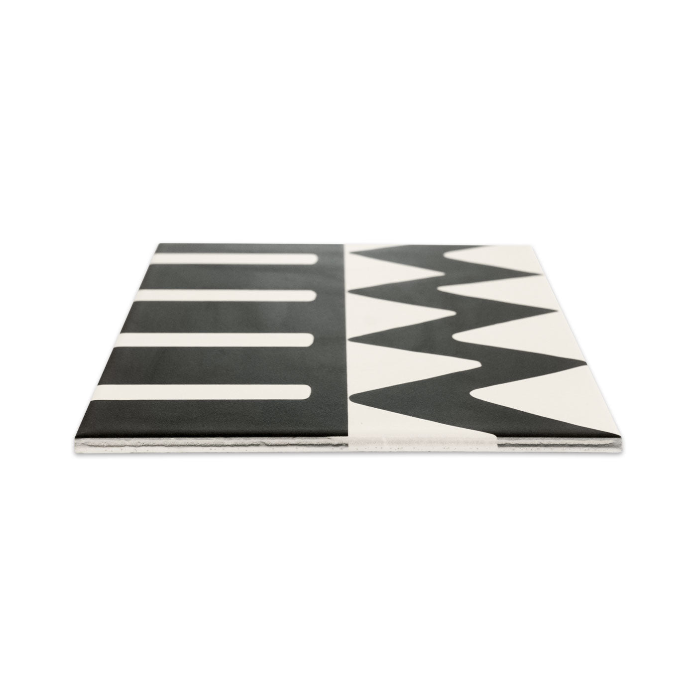 Pattern tile by Clay Imports in black and white with horizontal stripes on one half and zig-zag lines on the other, viewed at an angle.