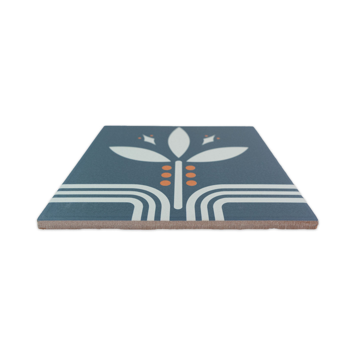 Midnight blue-grey pattern tile by Clay Imports with white stylized leaves and orange dots, shown from an angled side view.