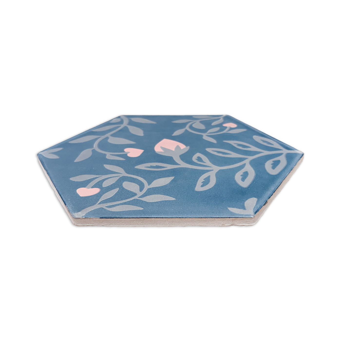 Blue hexagonal pattern tile by Clay Imports with grey vine and pink flower design, shown from the side.