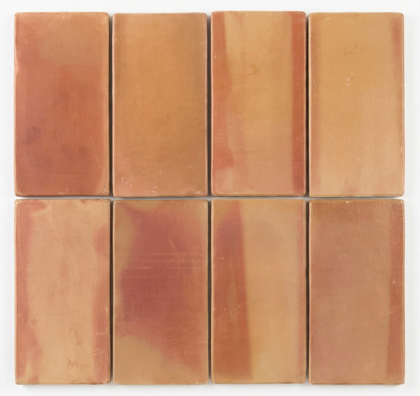 Eight rounded terracotta tiles by Clay Imports, showing varied reddish-orange and earthy brown hues.
