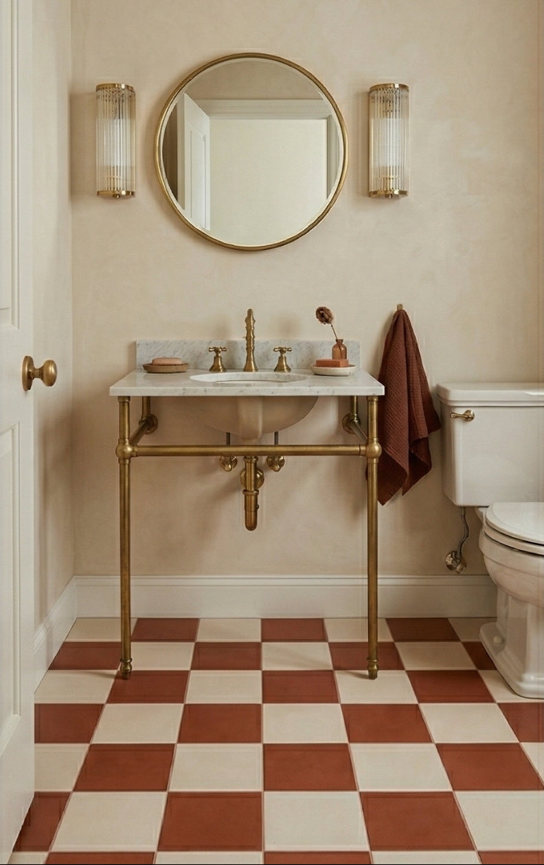 Bathroom with a gold vanity, round mirror, and checkered floor.