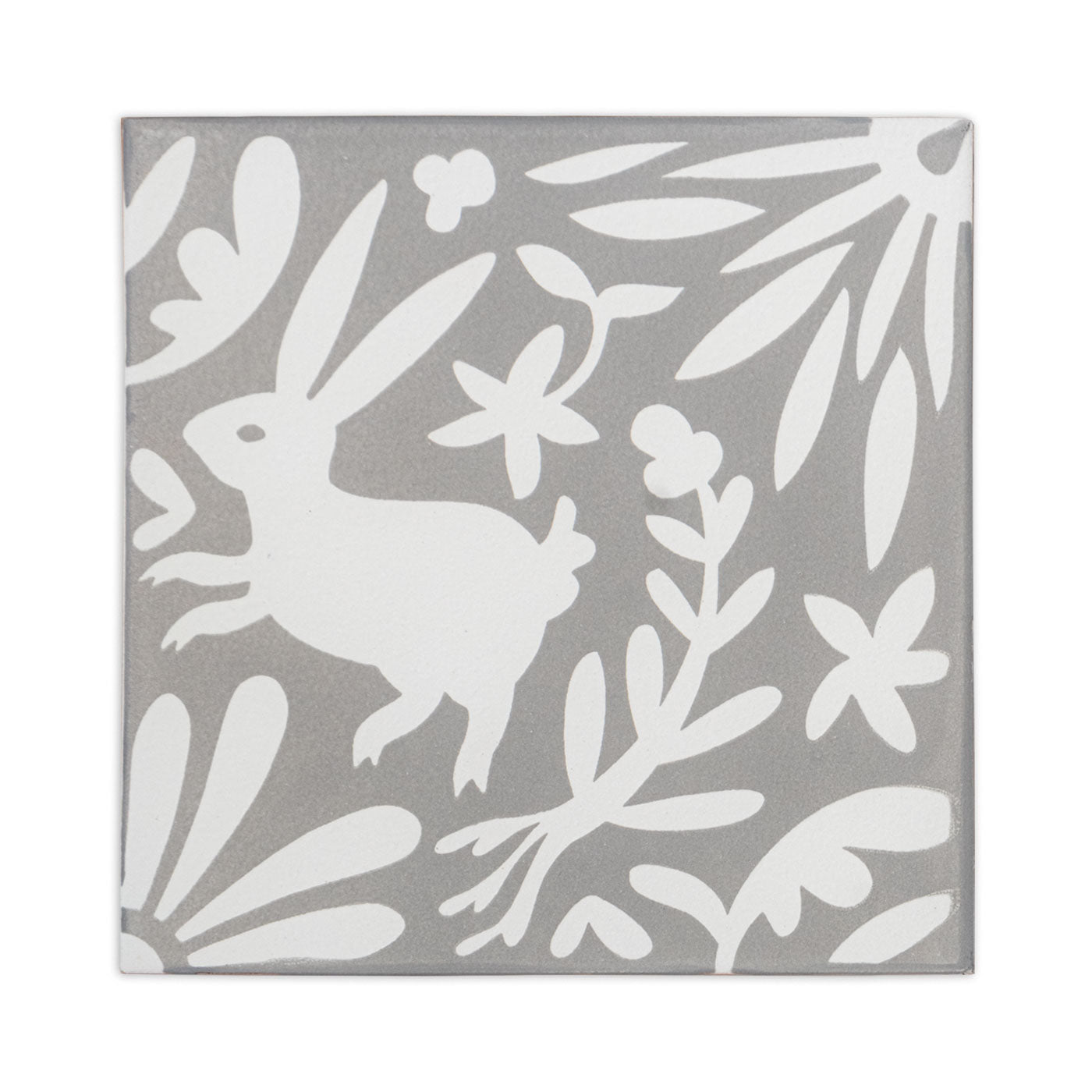 Grey and white decorative tile sample by Clay Imports, featuring a white rabbit amidst whimsical flowers and leaves.