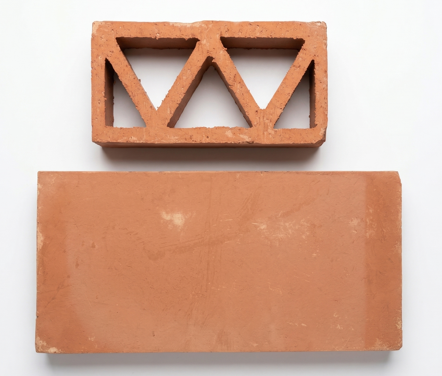 Terracotta breeze block with triangular cutouts by Clay Imports Breeze Blocks, shown above a solid rectangular tile on a white background.