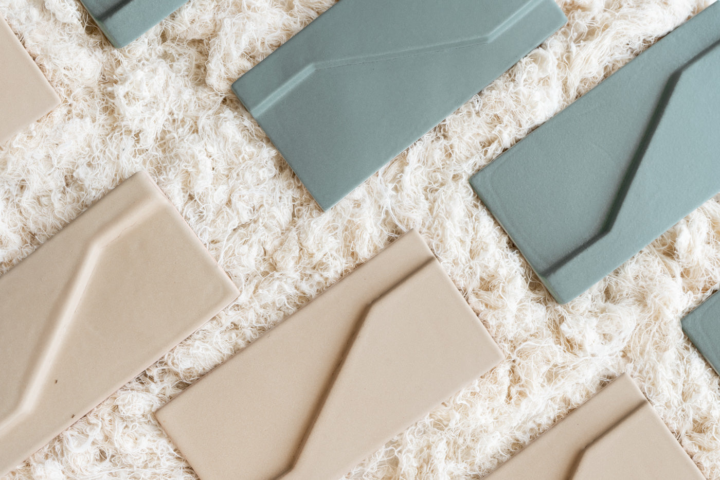 Rectangular 4x8 geometric tiles by Clay Imports in Templo green and beige on a textured white surface.