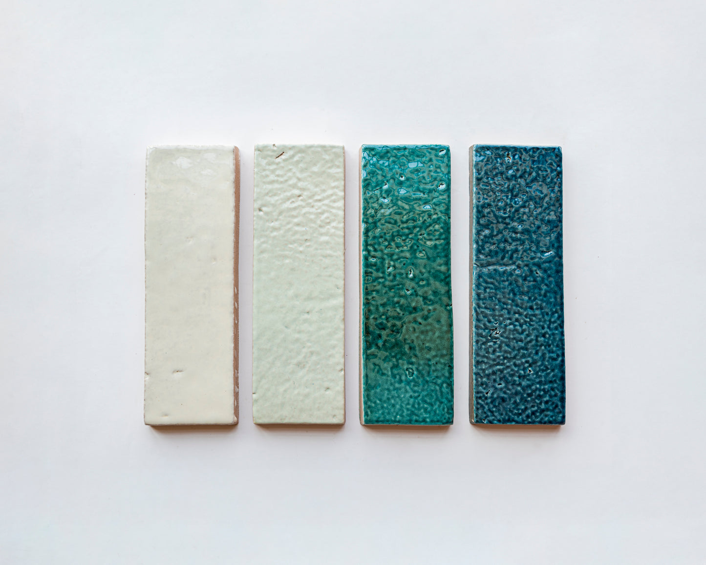 Botanical Teal textured Glazed Thin Brick by Clay Imports, deep blue-green with glossy finish, displayed in a color gradient.