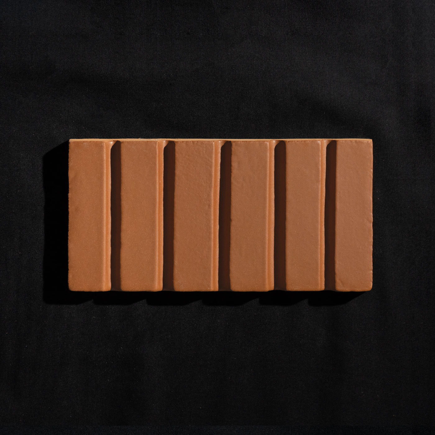 Otero Mamey 4x8 clay tile by Clay Imports with six raised vertical ribs on a black background.
