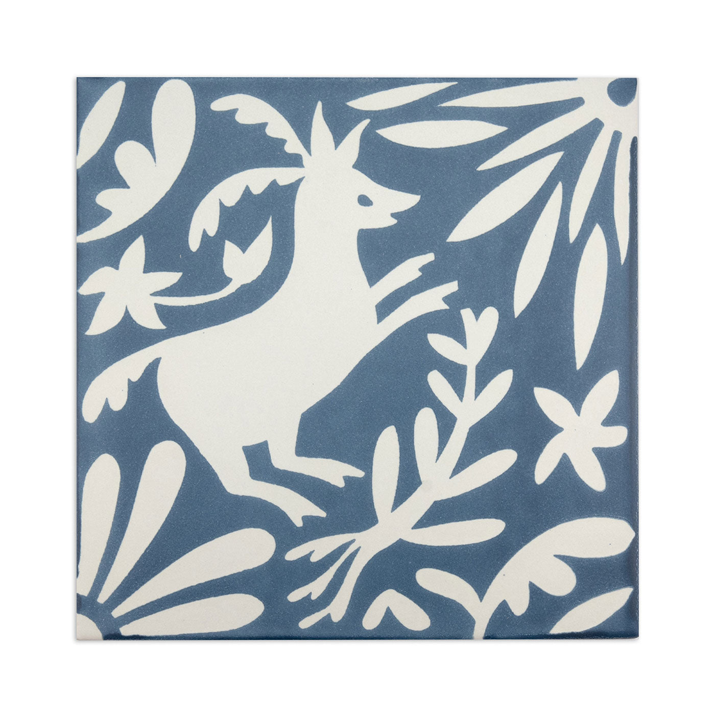 Blue and white square sample tile from Clay Imports with a stylized deer and botanical pattern.