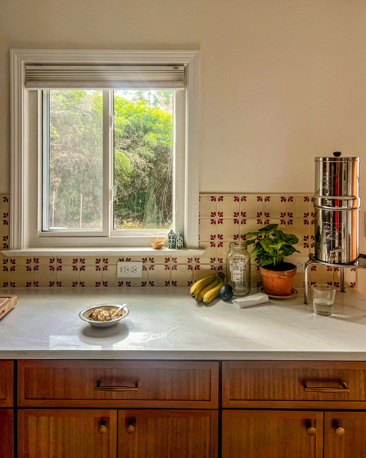 Cream Talavera tile with an oxblood red Tula floral pattern by Clay Imports Handmade Tile, installed as a kitchen backsplash.