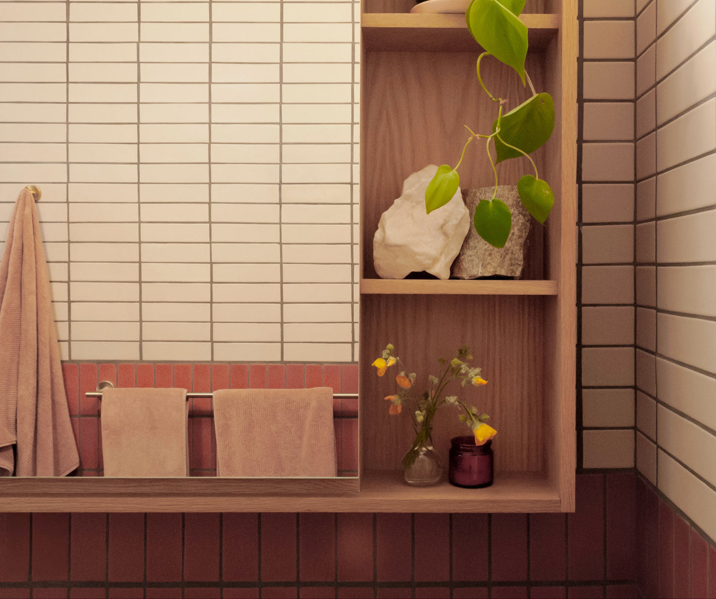 Rectangular Twine 2x8 clay tiles by Clay Imports in off-white and reddish-brown hues, styled with wood shelving and pink towels.