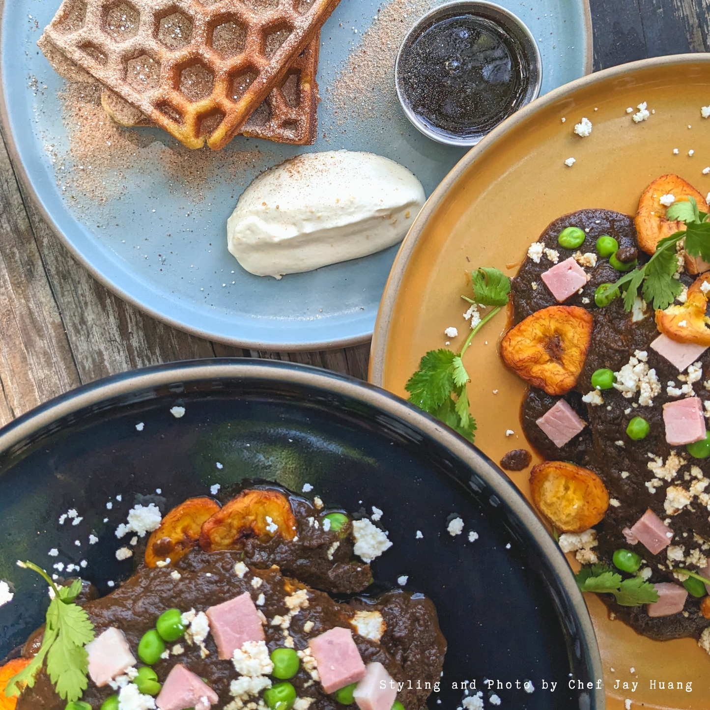 Rustic clay dinner plate by Clay Imports in blue, yellow, and black, filled with gourmet food.