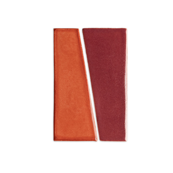 Two rectangular tile samples by Clay Imports, one orange and one plum, with a subtle shimmer, diagonally separated.