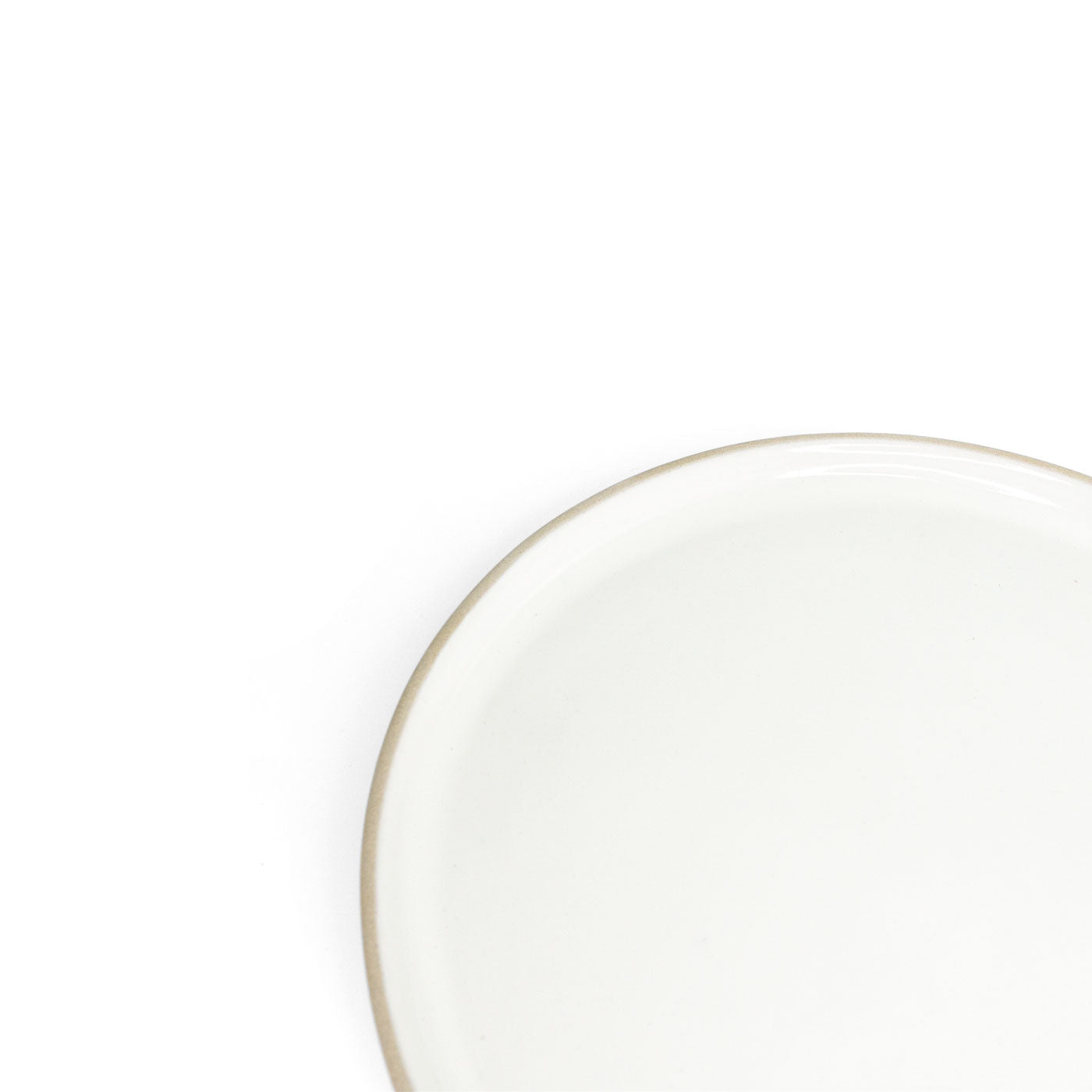 White dinner plate by Clay Imports with a light brown rim, shown in a cropped view.