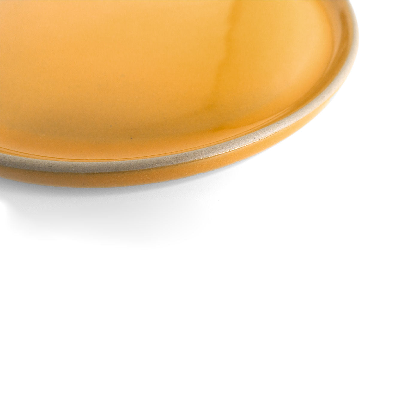Yellow dinner plate by Clay Imports with a grey rim, shown in a cropped, top-down view.