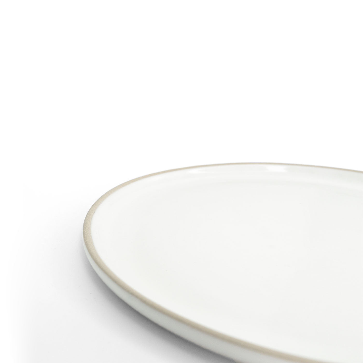White oval snack plate by Clay Imports with a visible unglazed clay rim, shown close-up.